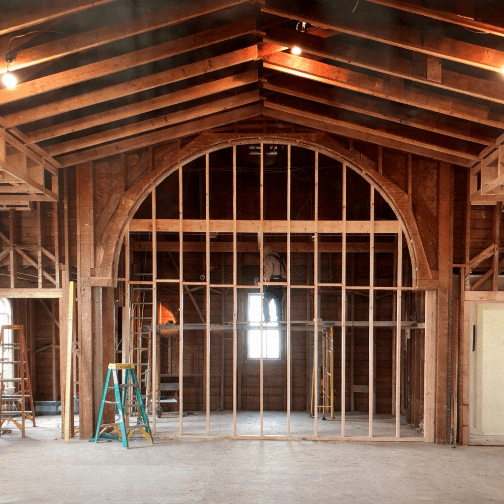 Community center interior arched timber framing during construction